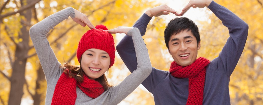 Chinese couple making heart shape with their arms