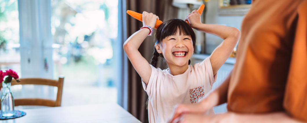 Playful young daughter with carrots
