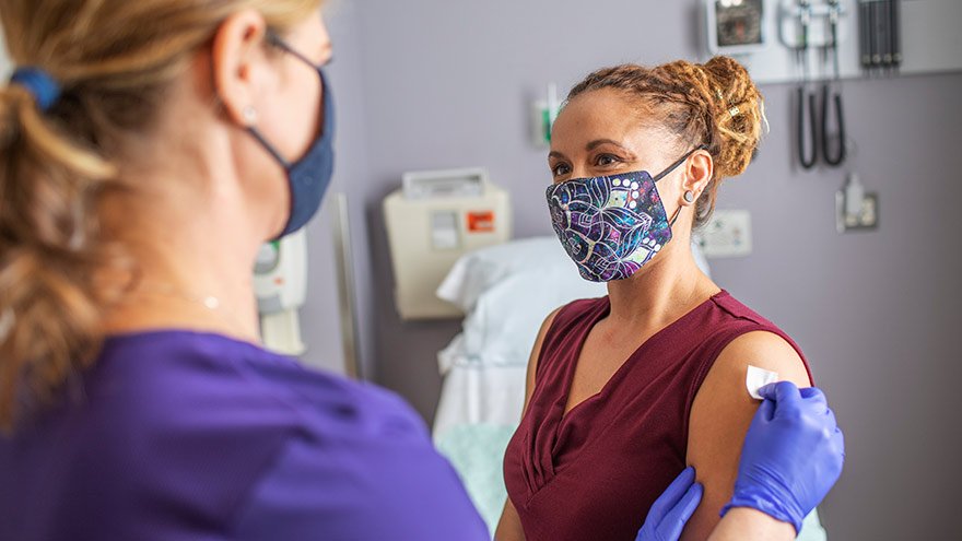 Woman receiving vaccine from Renown healthcare worker