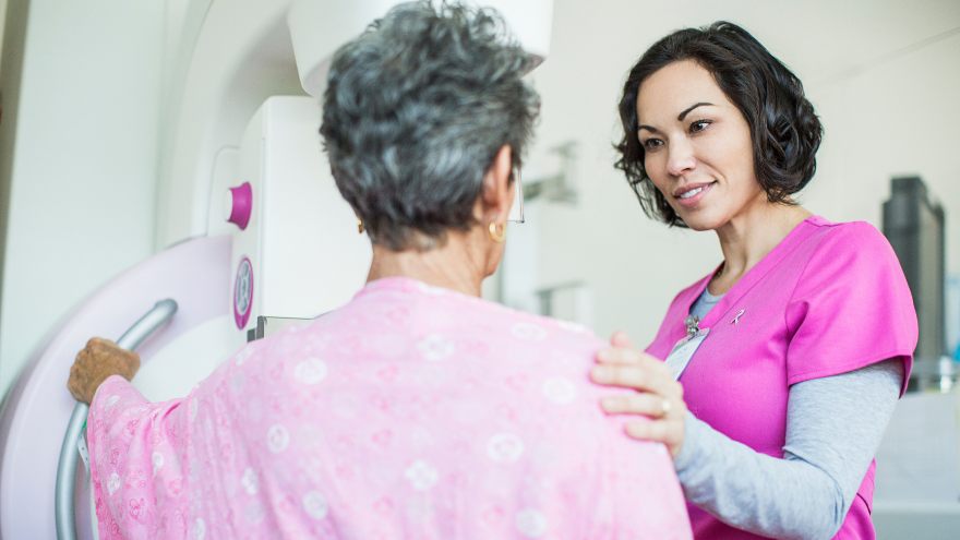 Woman with nurse in pink shirt getting mammogram