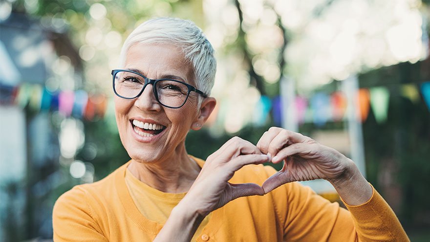 Happy senior woman making a heart sign with her hands