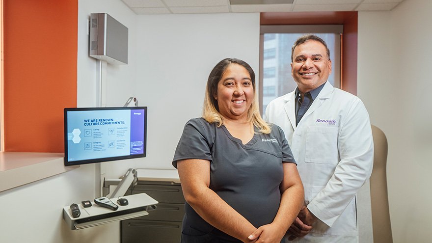 Dr. Kahlon posing with medical assistant in treatment room.
