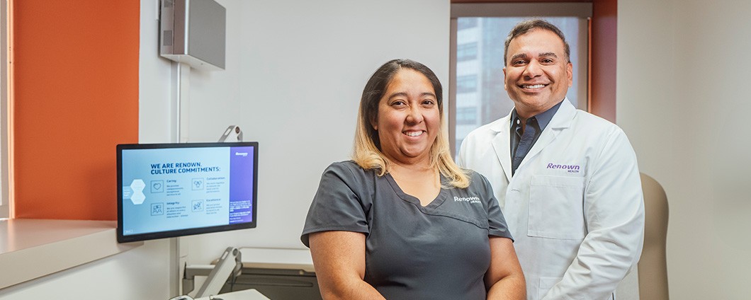 a man and a woman are standing next to each other in a hospital room .