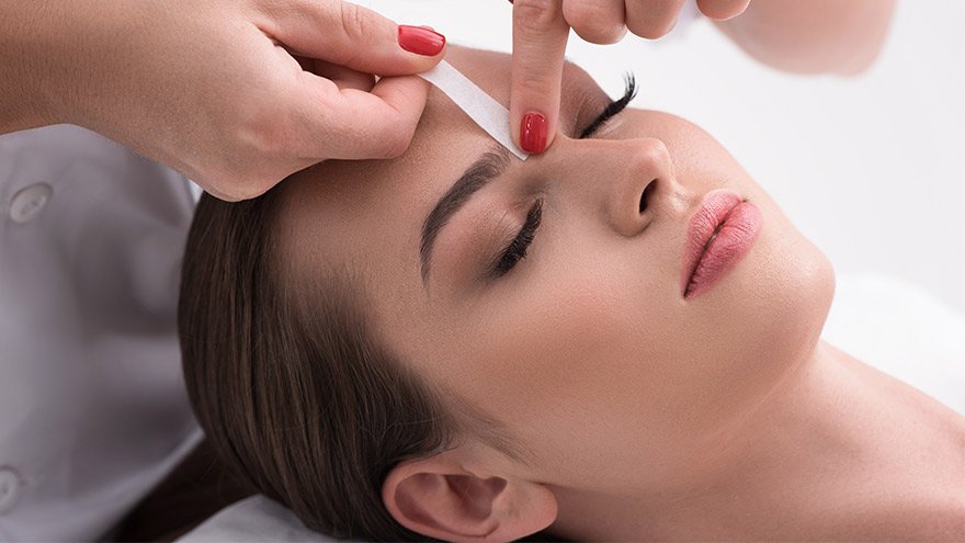 Woman getting a brow wax service