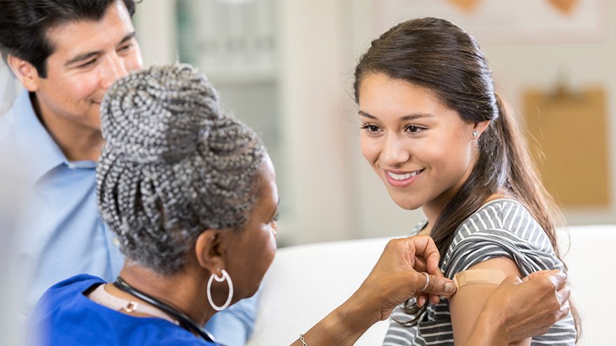 nurse putting band-aid on girls upper arm