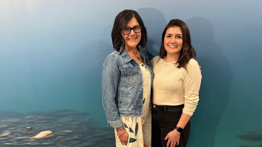 Toni and Emily Ruff, a mother and daughter, smile in front of a mural of Lake Tahoe.