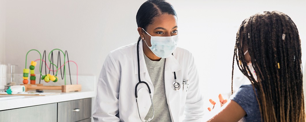 Pediatric doctor talking to little girl patient