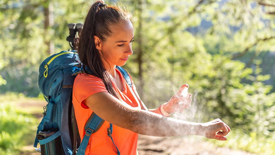 Woman applying bug spray outdoors