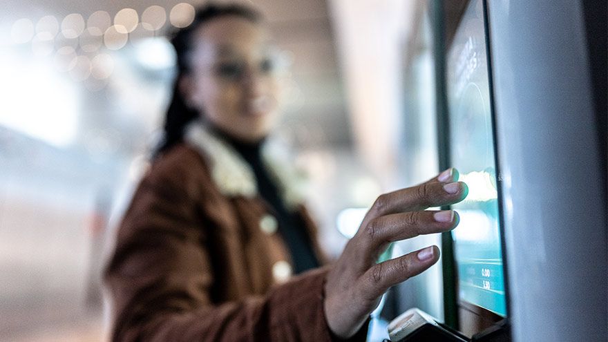 Close up of young woman checking in at a kiosk for her lab appointment