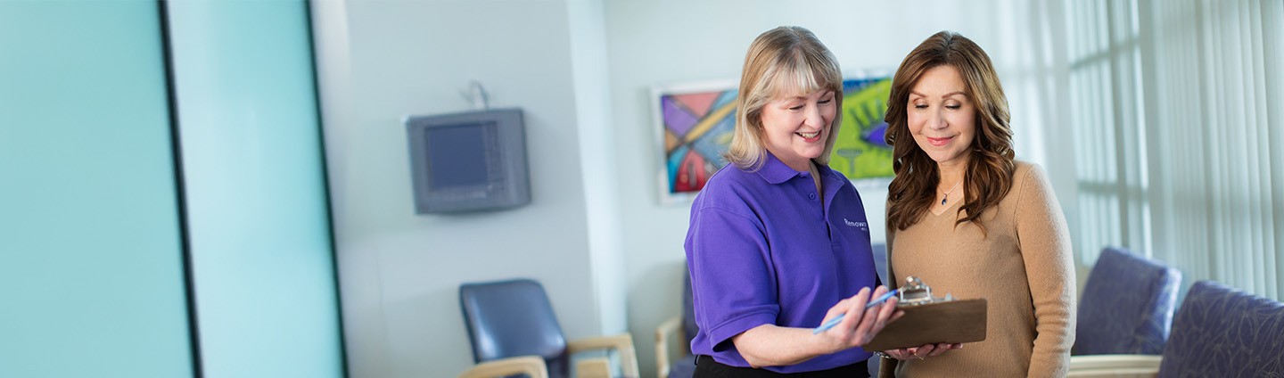 Healthcare staff member reviewing information with a patient about participating in a clinical research study