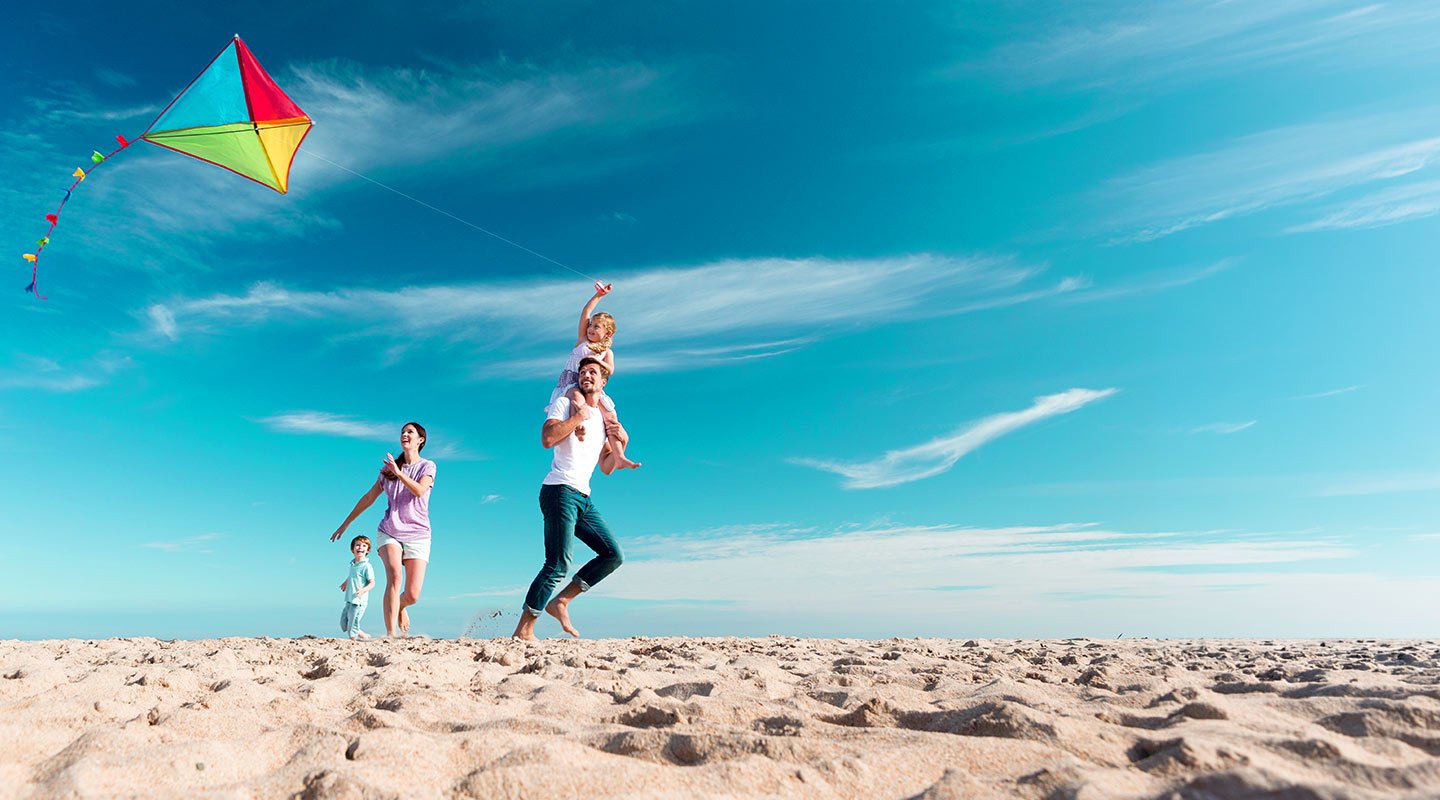 Family flying a kite at beach