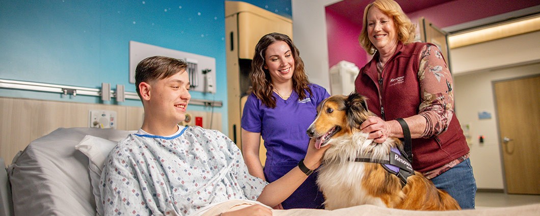 A Renown Health pet therapy volunteer visits patient with her dog