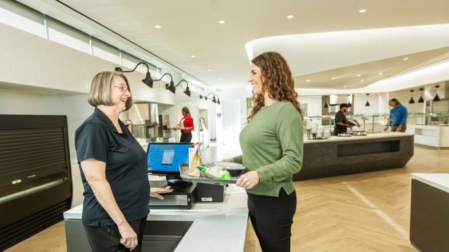 Cafe clerk at Renown South Meadows chats with woman holding a tray of food