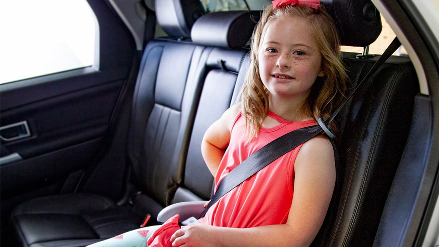 Older child sitting in back seat of car