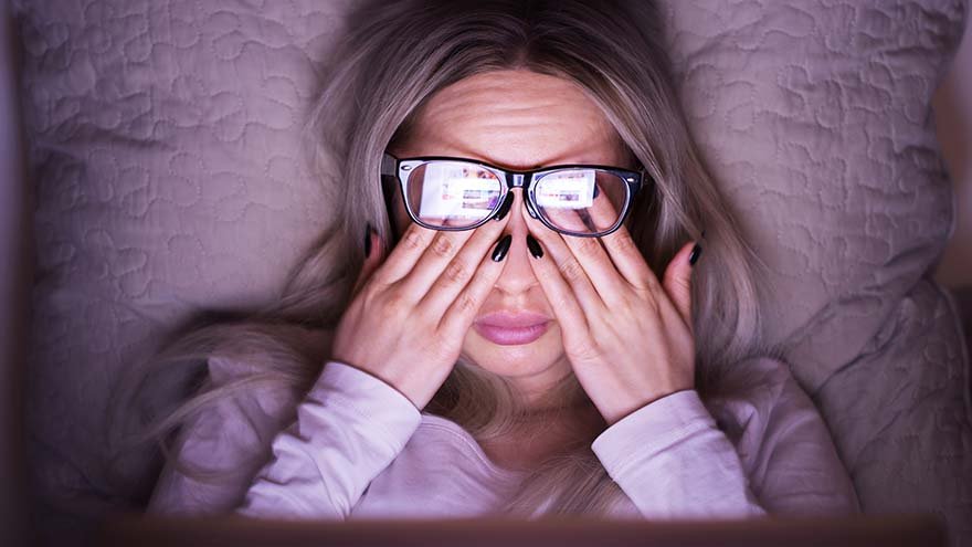 Woman in glasses rubbing her eyes