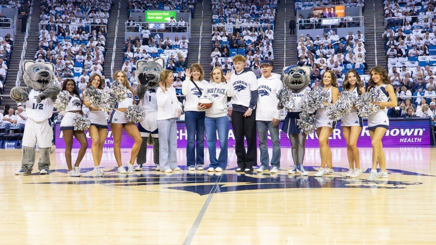 Amber Snow and loved ones pose for photo at UNR basketball game