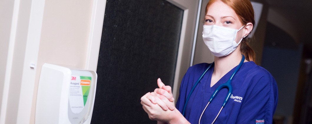 nurse wearing mask and sanitizing hands