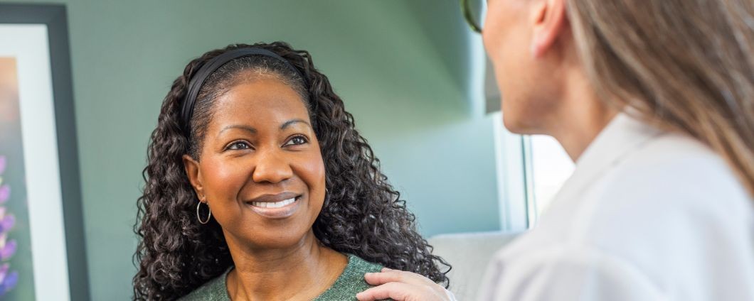 A female patient discusses high risk breast cancer screening with a doctor