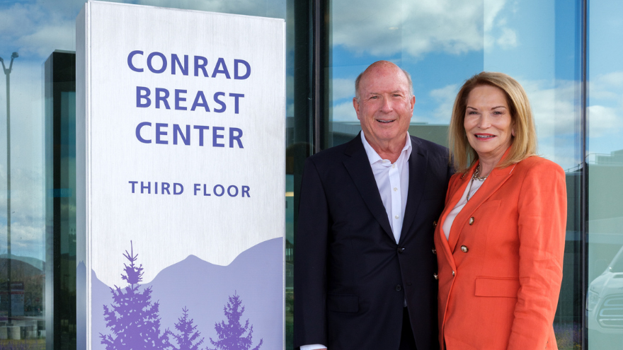 Jeanne and Raymon Conrad stand smiling out front of the Conrad Breast Center in south Reno