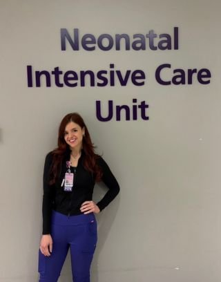 Ally posing in front of NICU signage