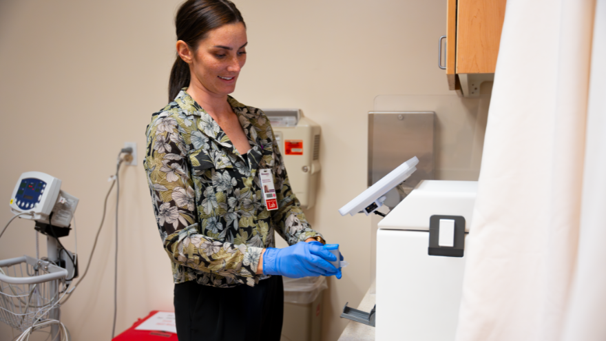 Breanna with Point-of-Care works on a patient's test.
