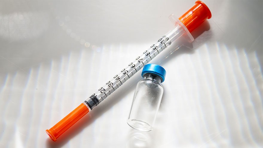 Close up of Empty Vial with Injectable Compounds Next to Syringe
