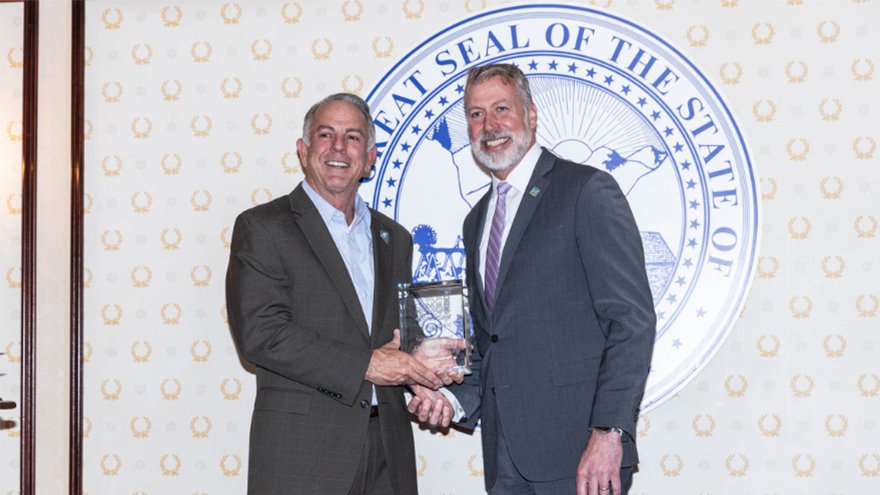Nevada Governor Joe Lombardo and Renown President and CEO Dr. Brian Erling pose for a photo as Dr. Erling accepts his Governor's Award.