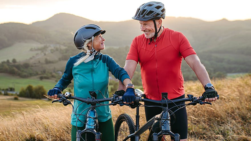 Portrait of senior couple on bike ride in autumn nature, looking at each other