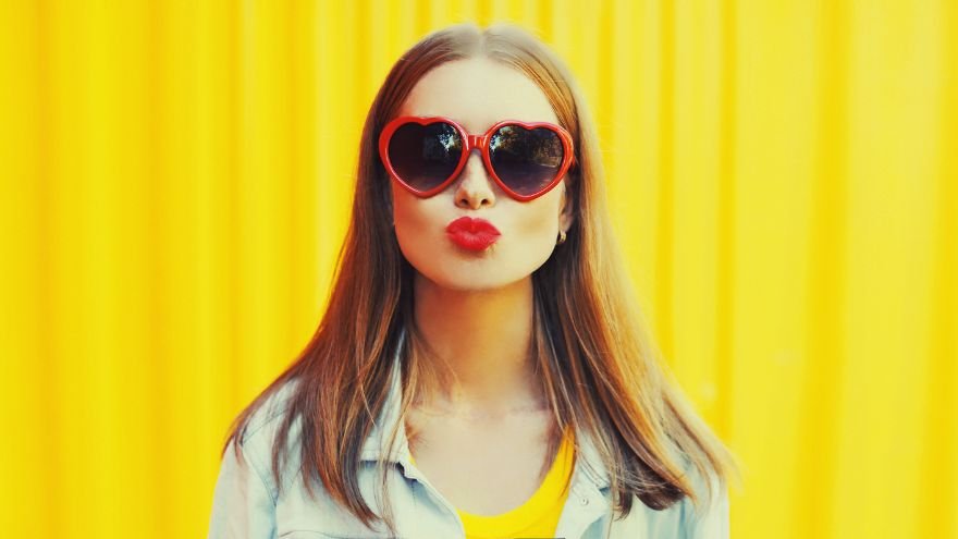 Woman pouting her lips wearing heart sunglasses