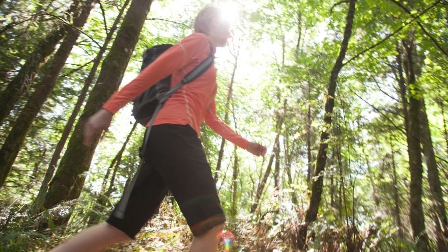 Woman hiking in woods wearing backpack