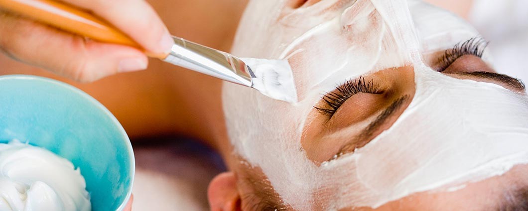 Woman having facial mask applied to her skin