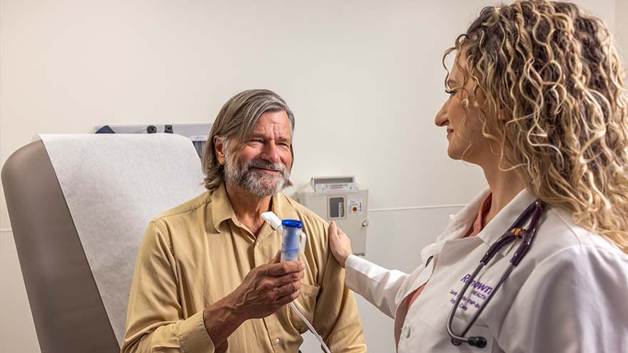 Man at Urgent Care getting nebulizer treatment from provider