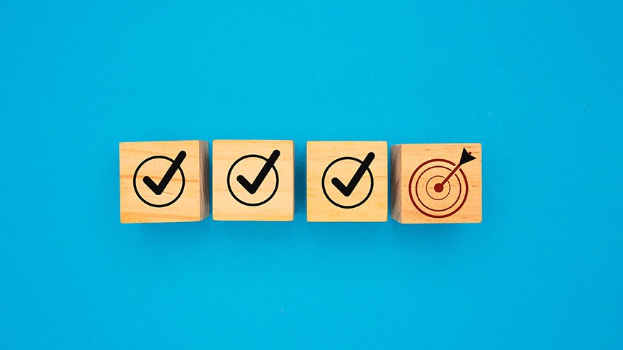Check marks on wooden blocks and a target icon on a blue background