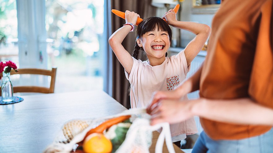 Playful girl holding carrors