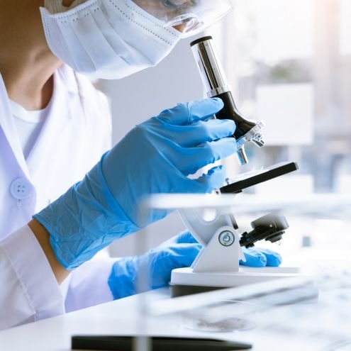 researcher looking through microscope