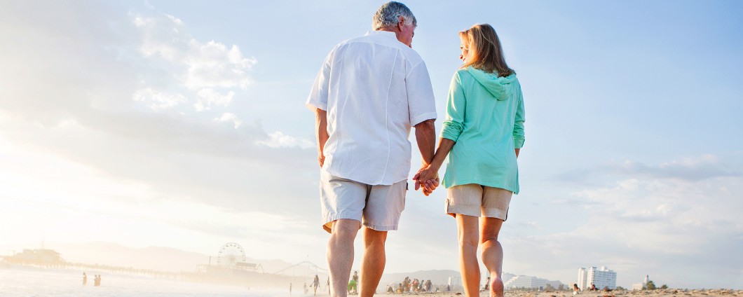Older couple walking on beach