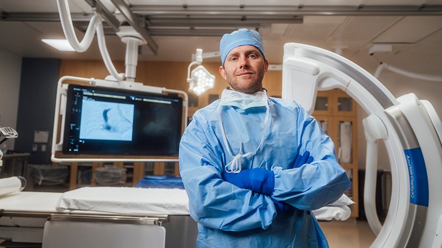 Doctor in surgical scrubs posing in treatment room