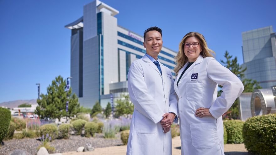 Dr. To and Dr. Thomas smile out front of Renown Regional LOVE sign