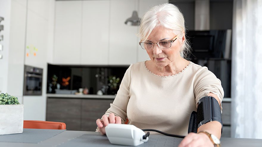 Senior Woman Checking Blood Pressure At Home
