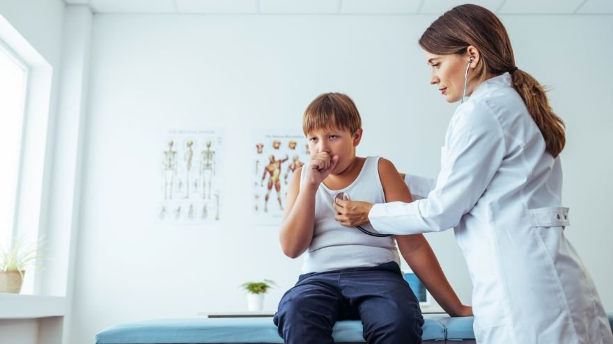 Female doctor checks a child for whooping cough symptoms