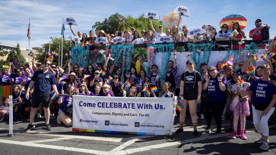 Volunteers from Renown, UNR Med and Orvis School of Nursing pose for a group photo in front of their parade float at the 2024 Northern Nevada Pride Parade.