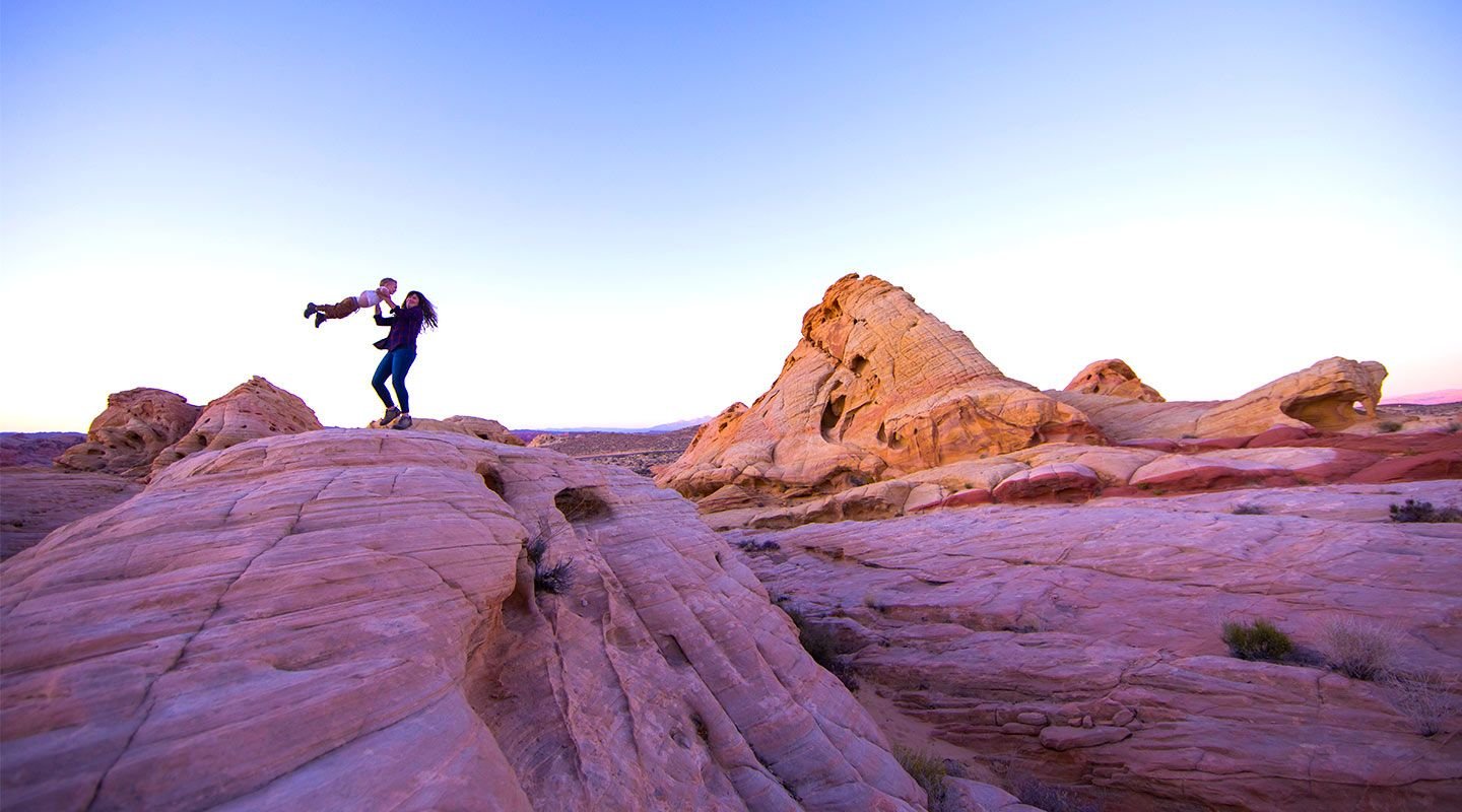Mom holding up her child in the desert