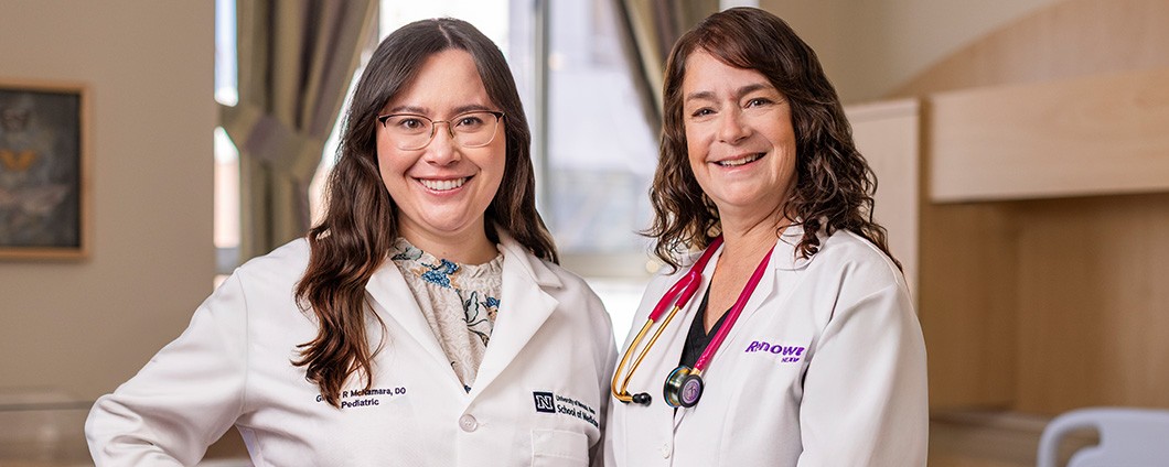 Women's health providers posing for photo in exam room.
