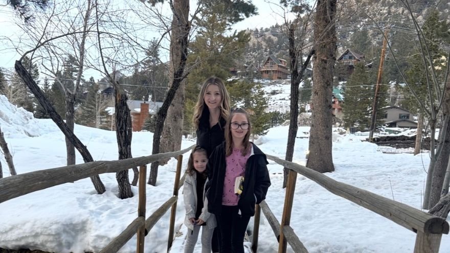 Kayla posing with daughter and family int he snow