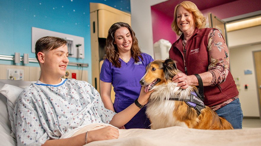 Therapy dog and owner visiting patient at Renown Health