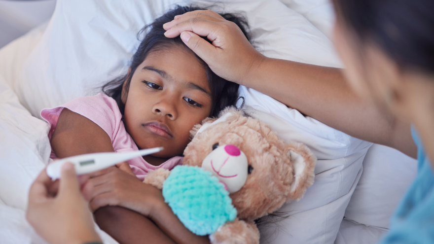 Mom taking young daughter's temperature