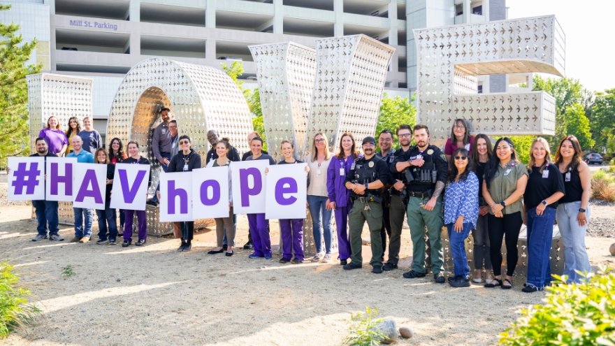 Renown Health employees pose in front of the LOVE sign with posterboards that spell out #HAVhope, in support of Hospitals Against Violence.