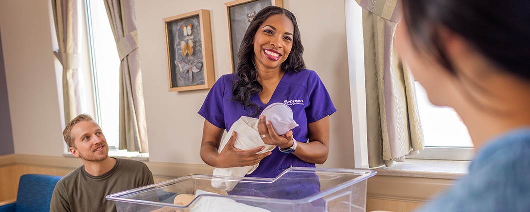 Renown providers holds a newborn while parents look on