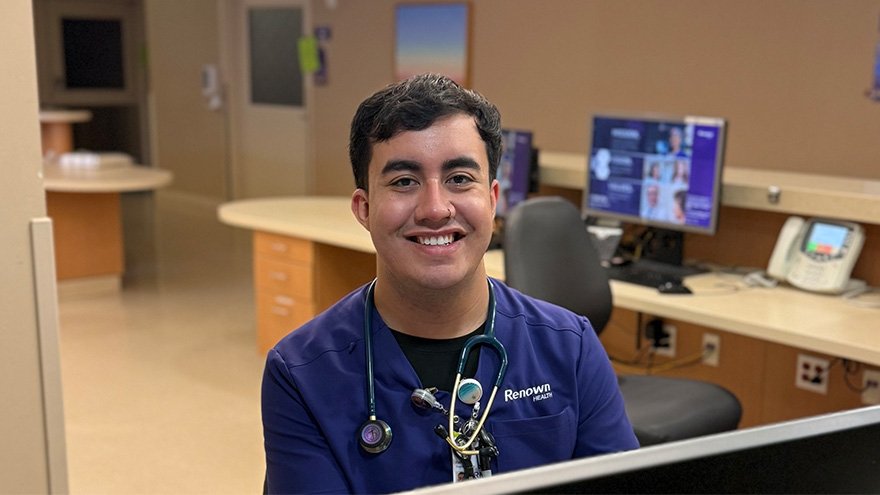 Robert Hernandez sitting at desk, posing for photo.