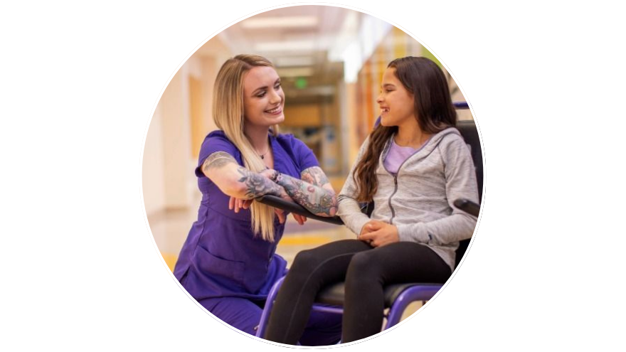 Renown nurse kneels down to share a moment with a young patient